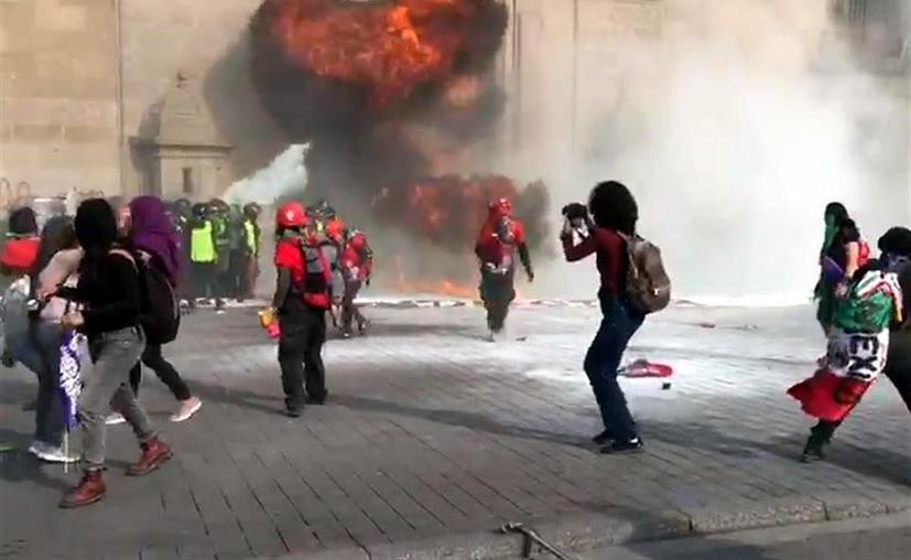 Embozadas estallan bombas molotov en puerta de Palacio Nacional y la pintan de rojo